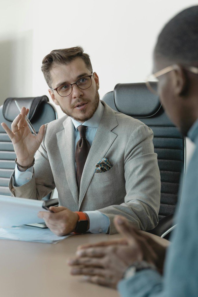 Consultant discussing options with a client in a professional office setting.